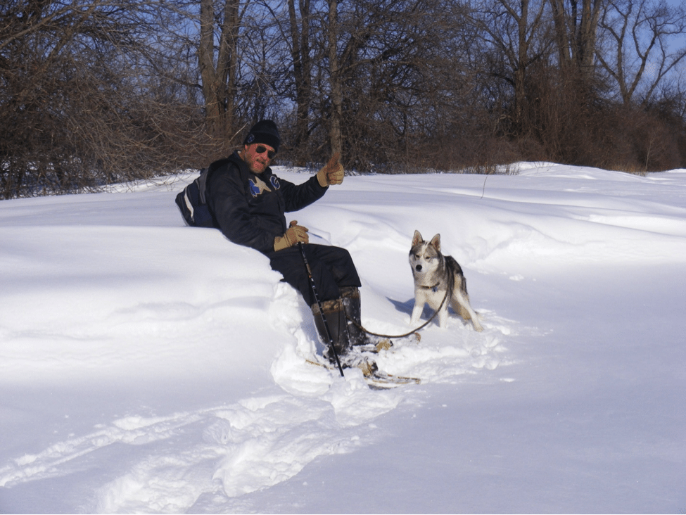 A man and his husky enjoying the snow