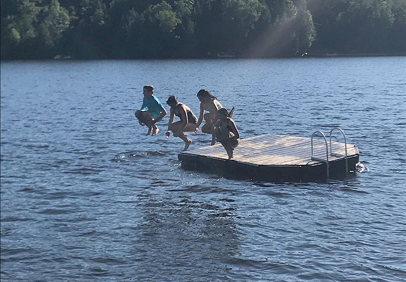 Kids jumping off dock into water