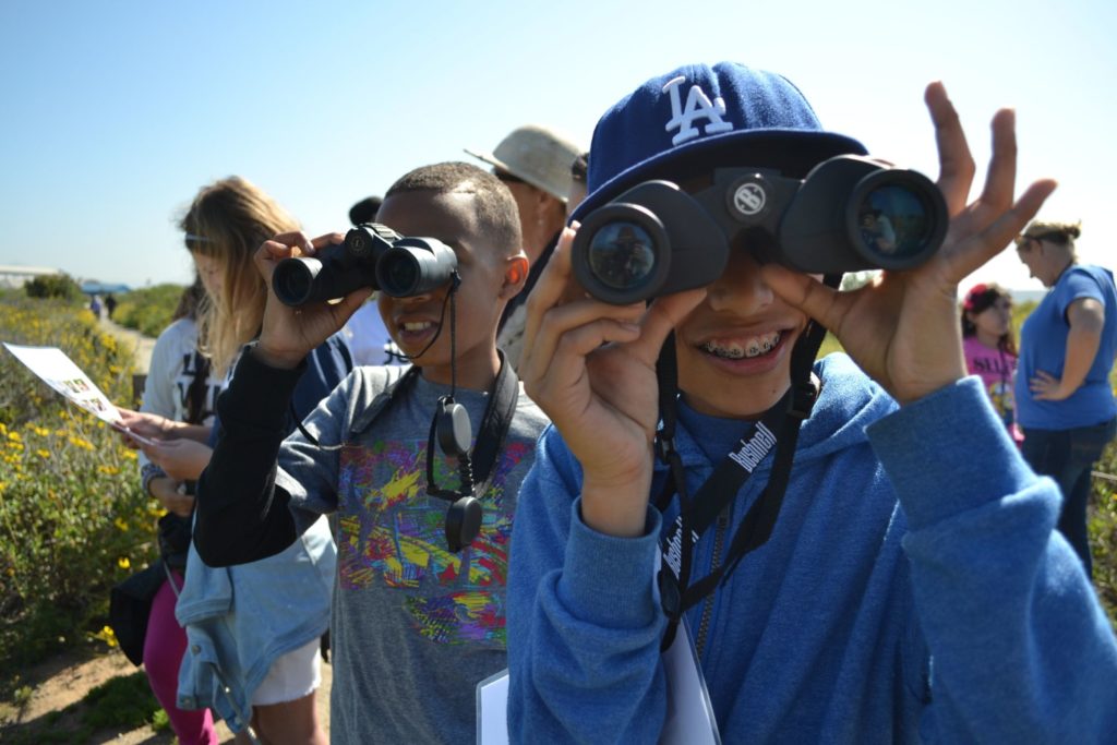 Kids wtih binoculars learning outside